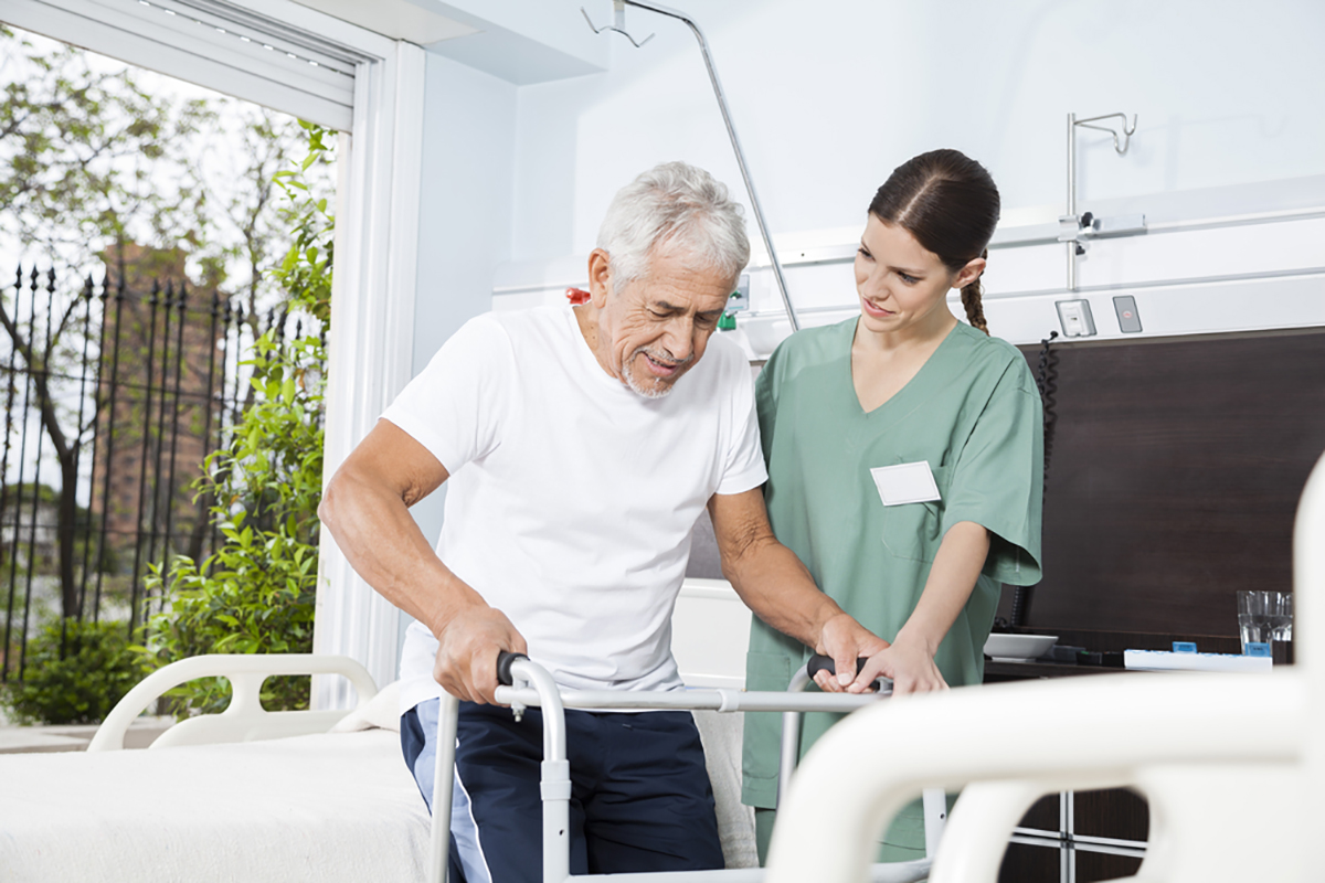 Medicare Insurance - Elderly man using walker in a long term care facility