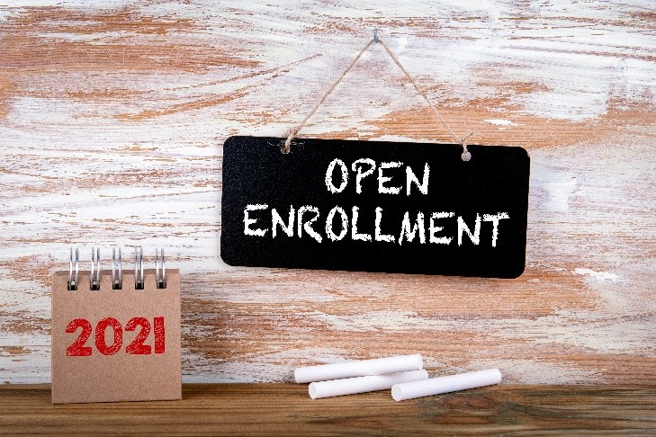 open enrollment written on a blakc chalkboard next to a calendar marked 2021